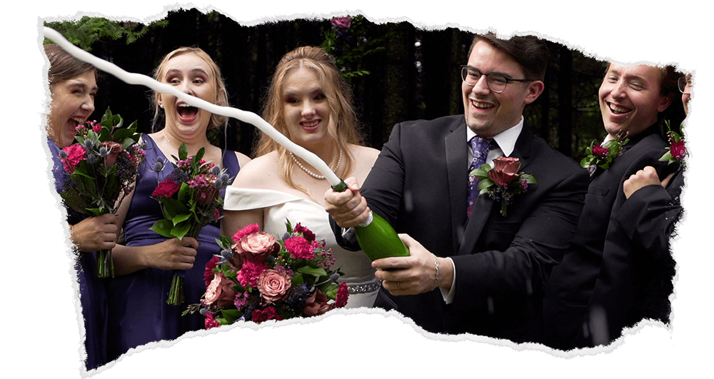 Newlyweds and bridal party celebrating with champagne spray.