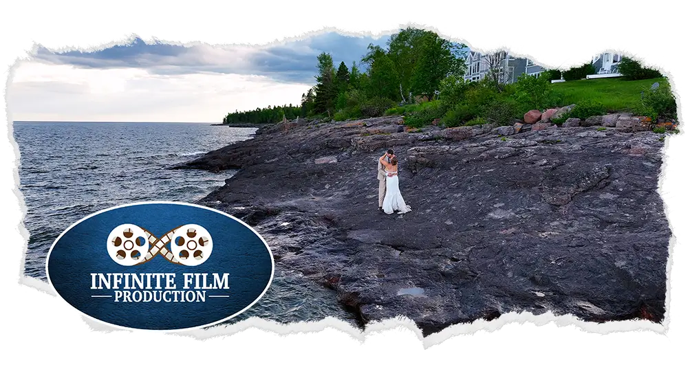 Bride and groom embracing on rocky shoreline by Lake Superior in Duluth, Minnesota.